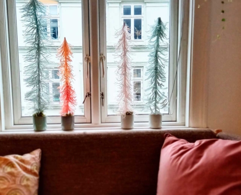 Juletræer i crepe papir i vindueskarm.